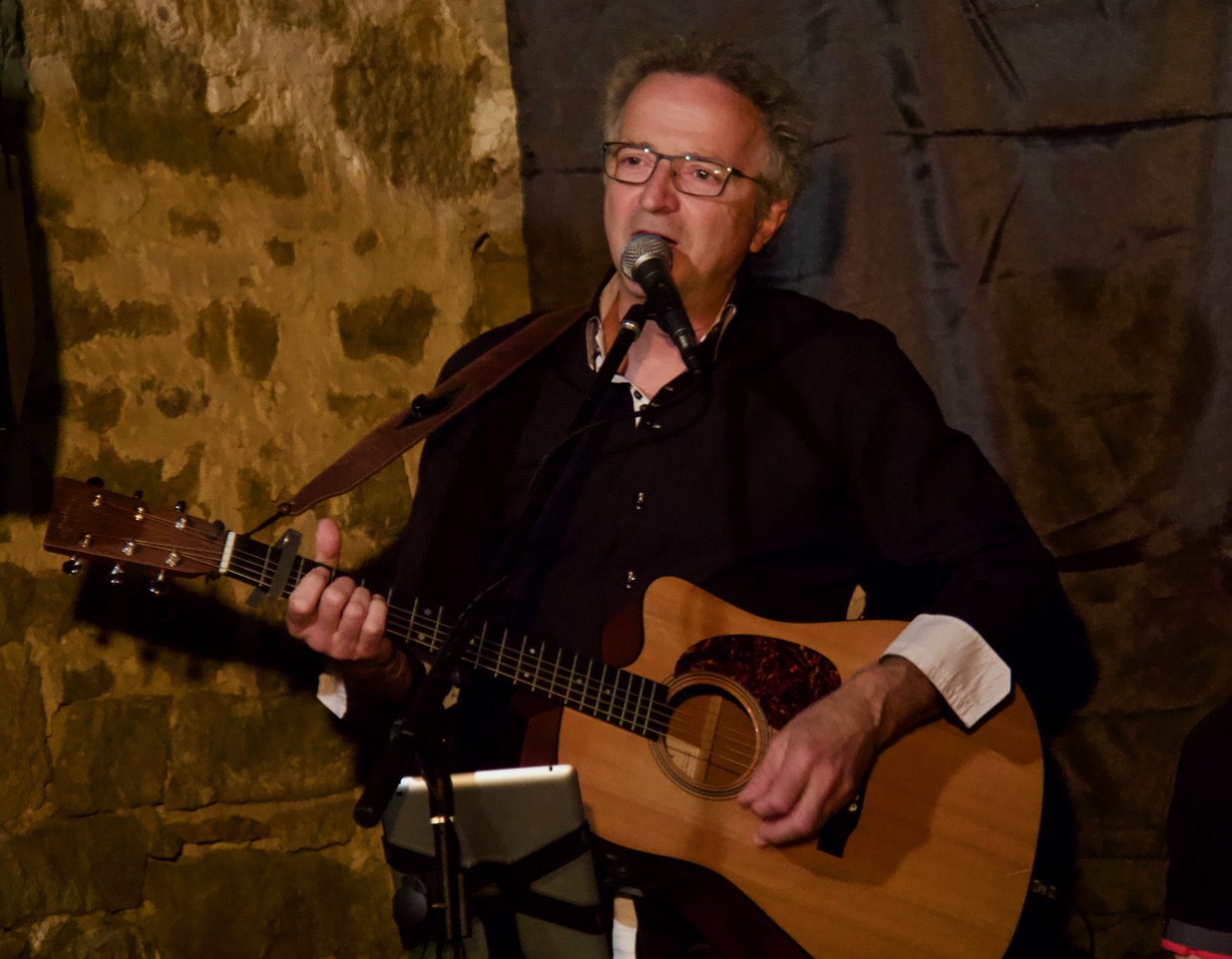 young man wearing shades and a hat with a beard, tattos and ear piercings
